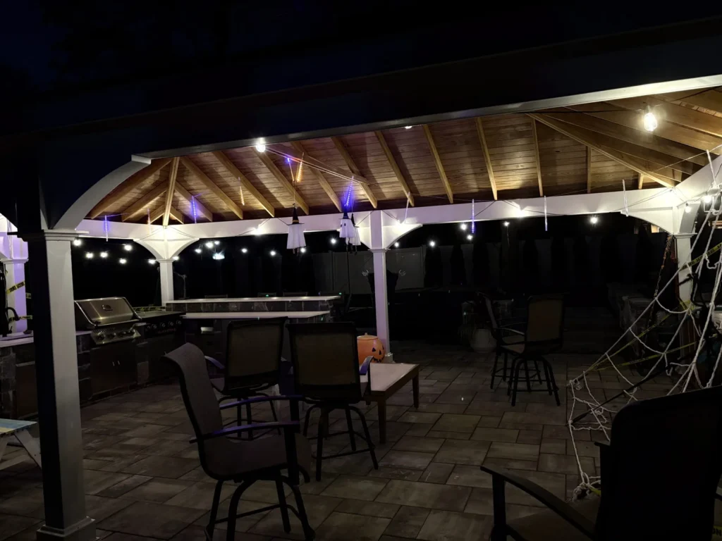 Covered outdoor patio with decorative string lights installed for backyard entertainment area