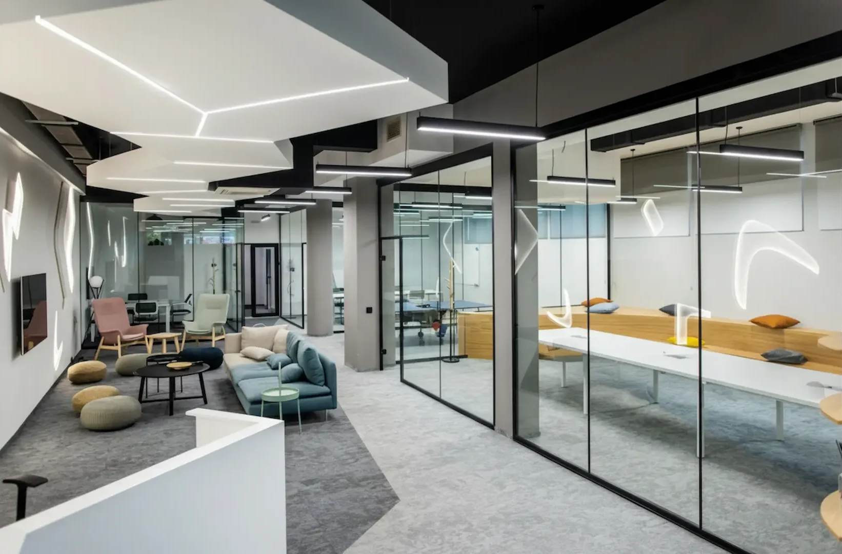 Business Lighting: High-end corporate lounge featuring architectural business lighting with geometric recessed ceiling LEDs and modern linear pendants.