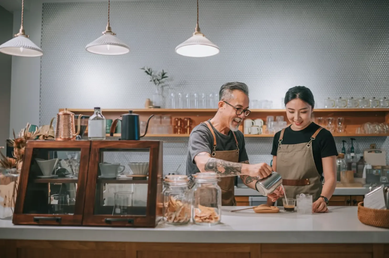 Business Lighting: Inviting business lighting in a modern cafe featuring white ceramic pendant lights installed over a wooden service counter.