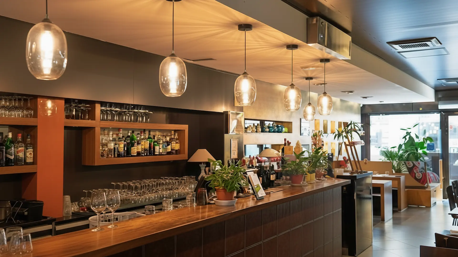 Business Lighting: Upscale restaurant bar in Suffolk, NY featuring warm business lighting with elegant glass pendant fixtures over a service area.
